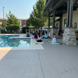people doing yoga by a pool
