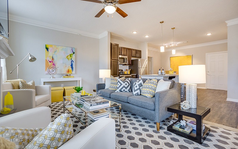 Spacious well lit living room with wood floors and large windows 