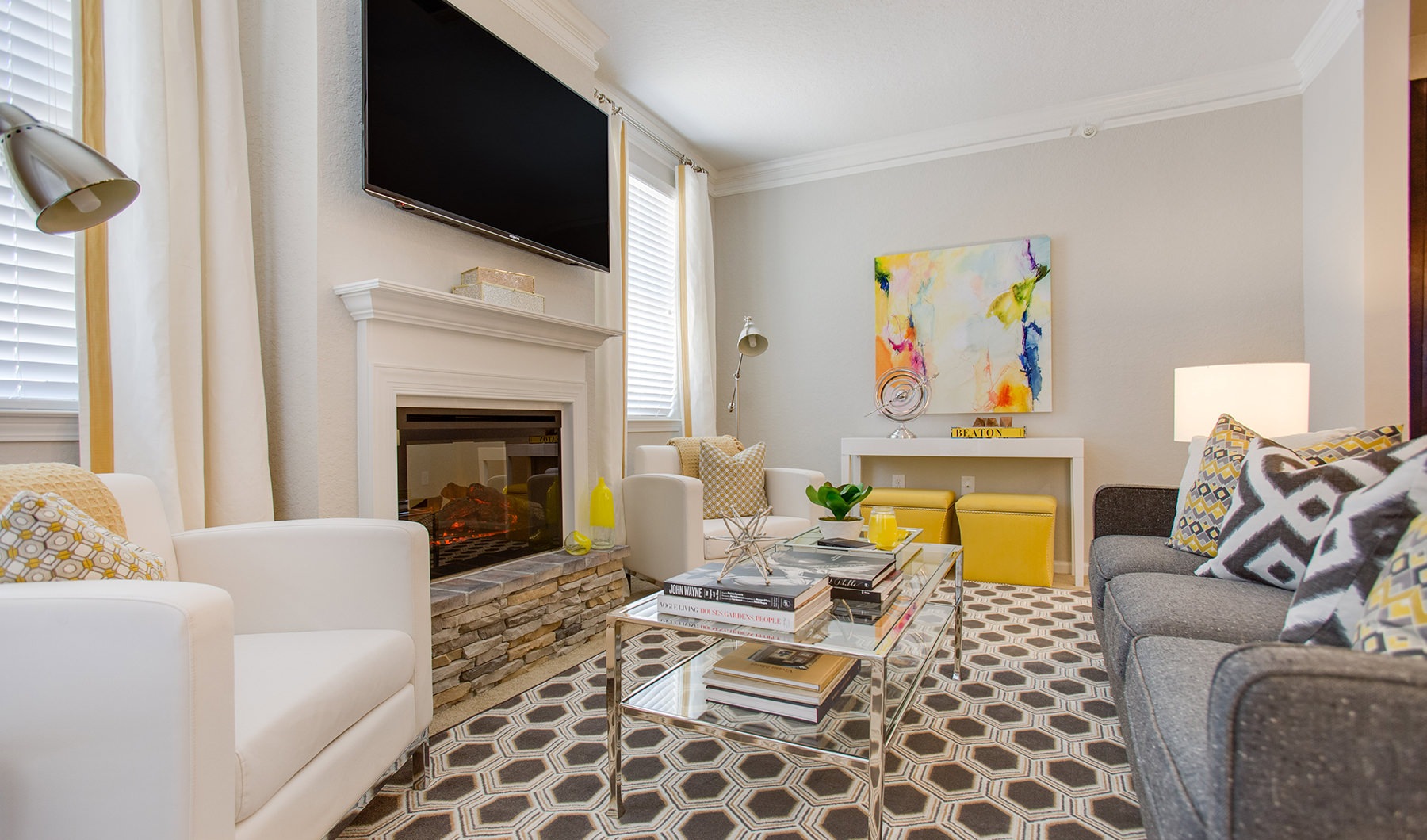 Spacious and well lit living room with wood flooring, large windows and open access to the kitchen.